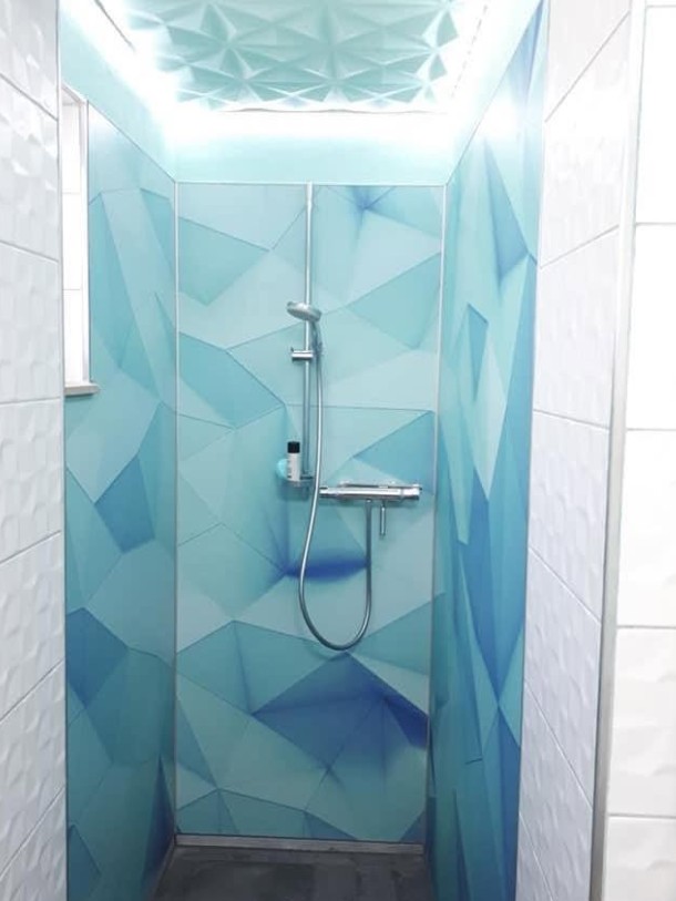 Duschrückwand mit blauem geometrischem Motiv