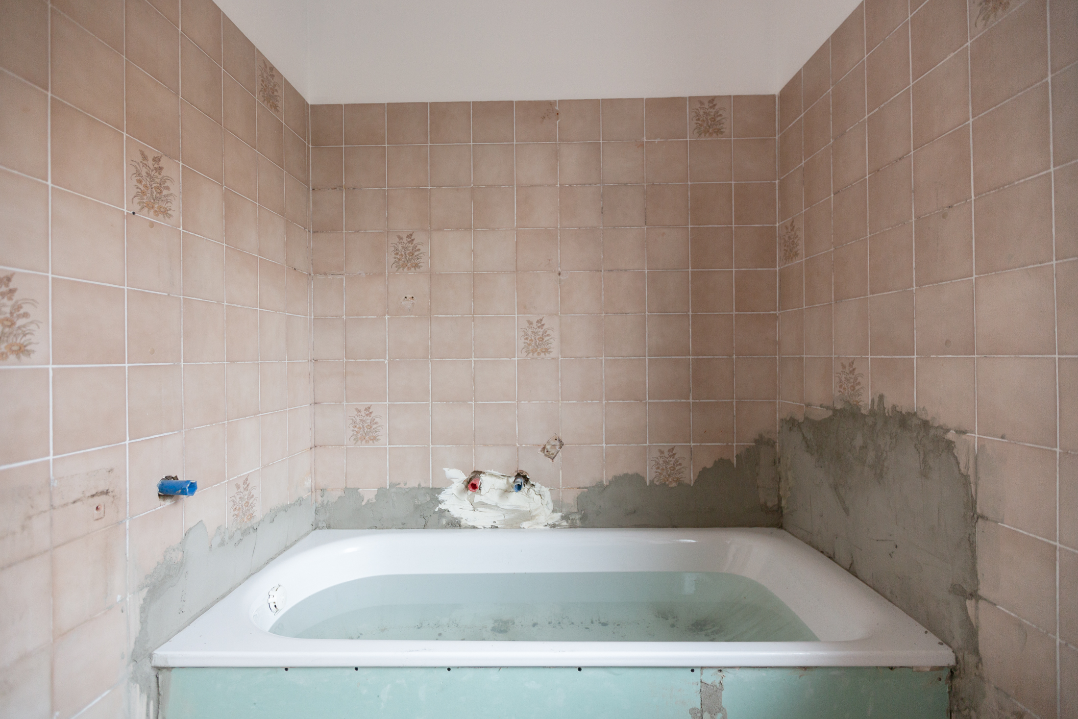 Badezimmer vor der Renovierung mit alten rosa Fliesen
